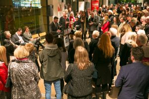 Large group of people, as seen form behind looking at the male speaker for SALA opening Night 2014