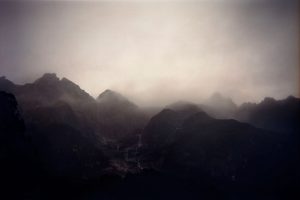 A misty mountain range photograph in purple tones.