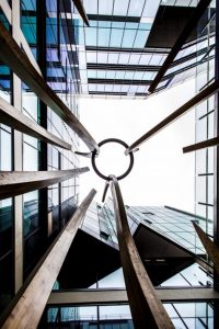 An image of the sky as seen between four tall buildings