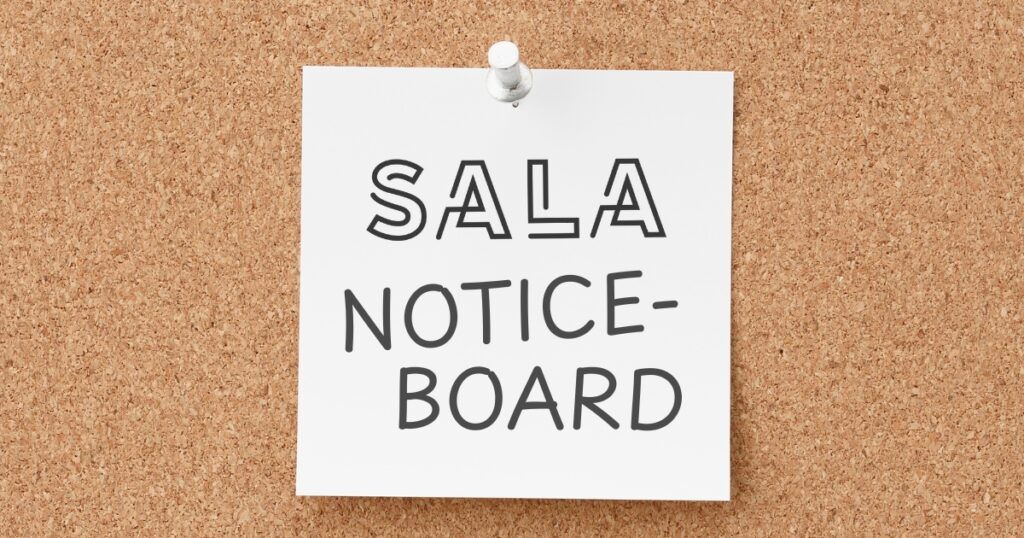 a white post-it note pinned to a corkboard reads 'SALA NOTICEBOARD'